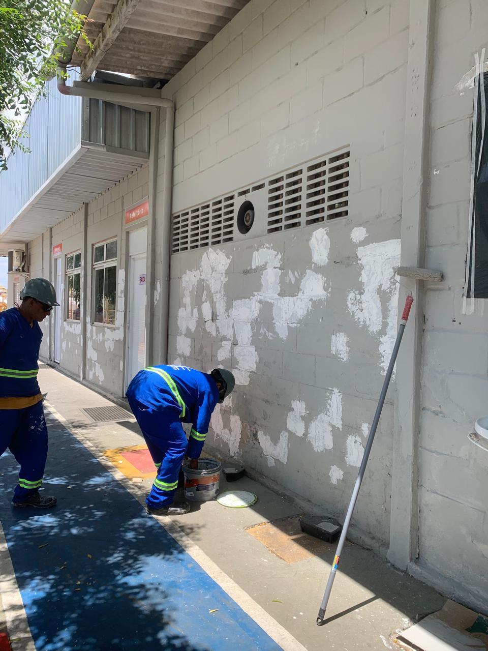 Equipe com uniforme e equipamentos de proteção executa reparo em parede de alvenaria